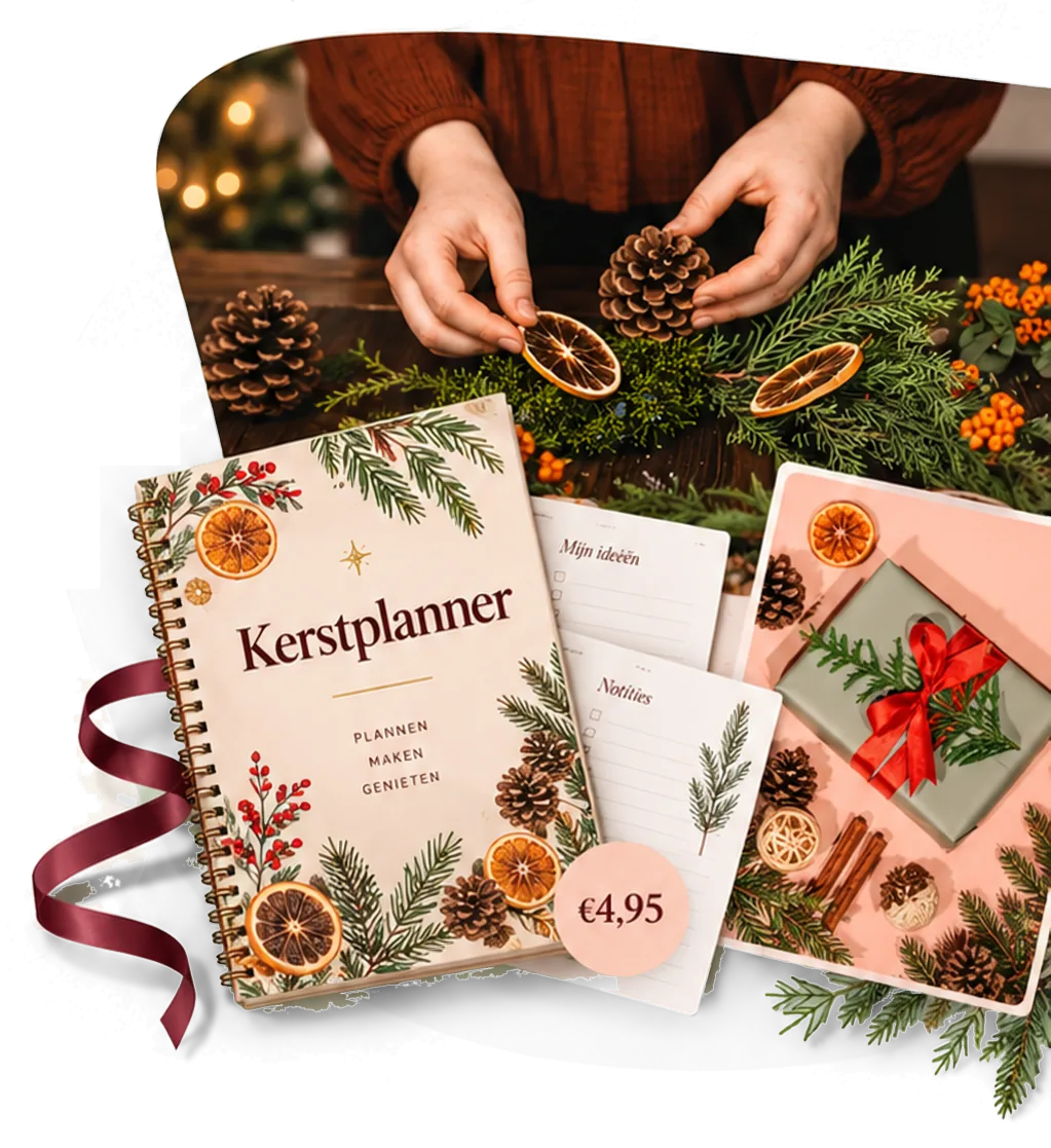 Handen schikken dennenappels en gedroogde sinaasappelschijfjes op groen; ervoor de Kerstplanner met kerstillustraties, notitievellen ‘Mijn ideeën’ en ‘Notities’, een roze kaart met kerstcadeau en een bordeauxrood lint. Prijs: €4,95.